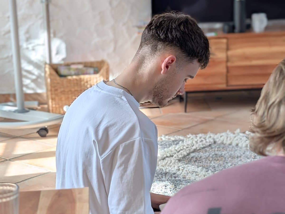 Ein Teilnehmer im weißen T-Shirt sitzt am Boden und schaut konzentriert nach unten