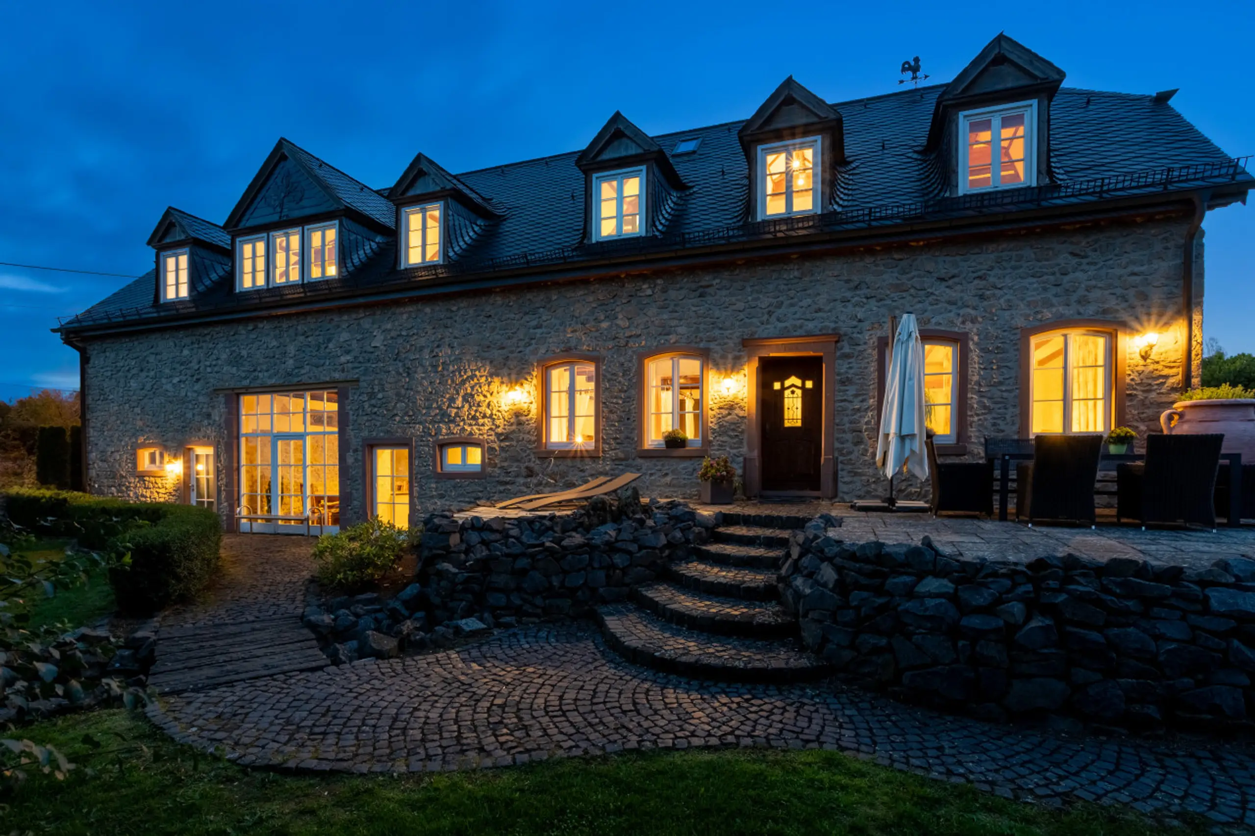 Die Landhausvilla am Abend, die Fenster erleuchtet